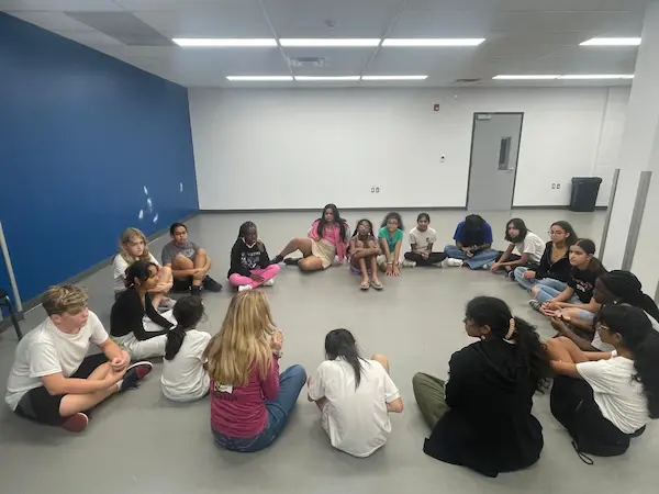 Students taking part in a group drama class